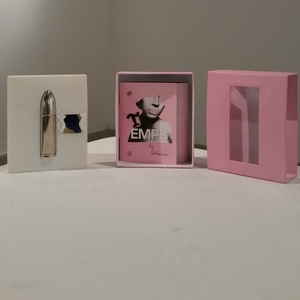 From left to right: reusable stainless steel perfume vial in the shape of a bullet; (centre) Handmade book; (right) cardboard case for the artwork.